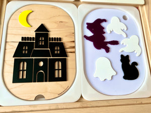 Wooden shapes puzzle featuring a black haunted house with a yellow crescent moon and separate ghosts, witch, and cat pieces