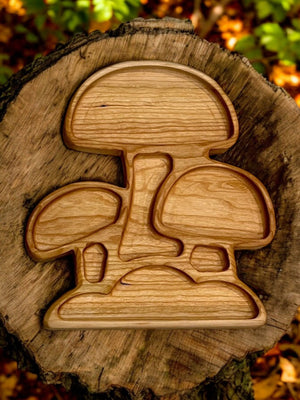 Wooden puzzle shaped like three stylized mushrooms on a tree stump with autumn leaves in the background