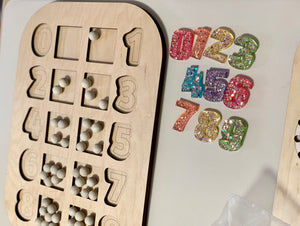 Wooden counting number puzzle Flisat table top insert with white wooden balls and colorful resin numbers on white surface