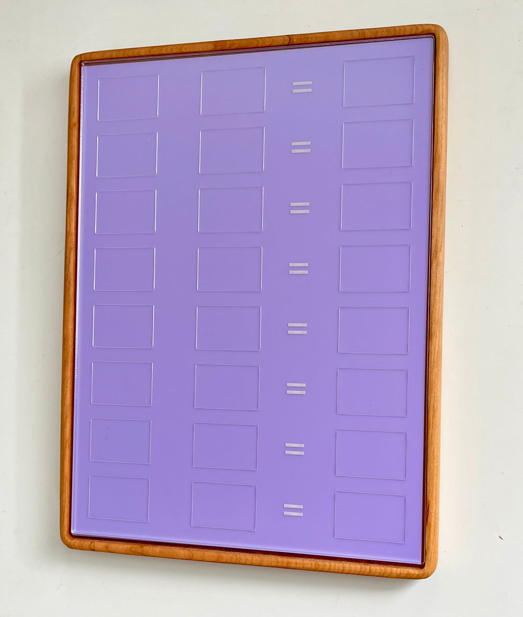 Tall wooden rectangular writing sensory tray holding purple dry erase insert with math equation boxes and equal signs on white background