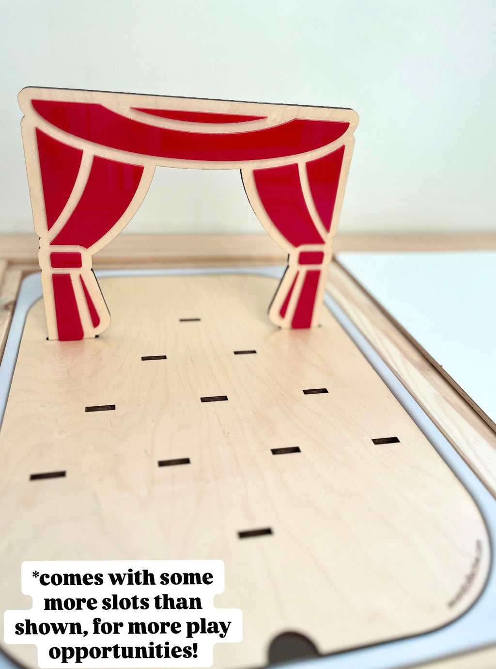 Wooden playboard featuring laser-cut red theater curtains with multiple slots for attaching customizable pieces