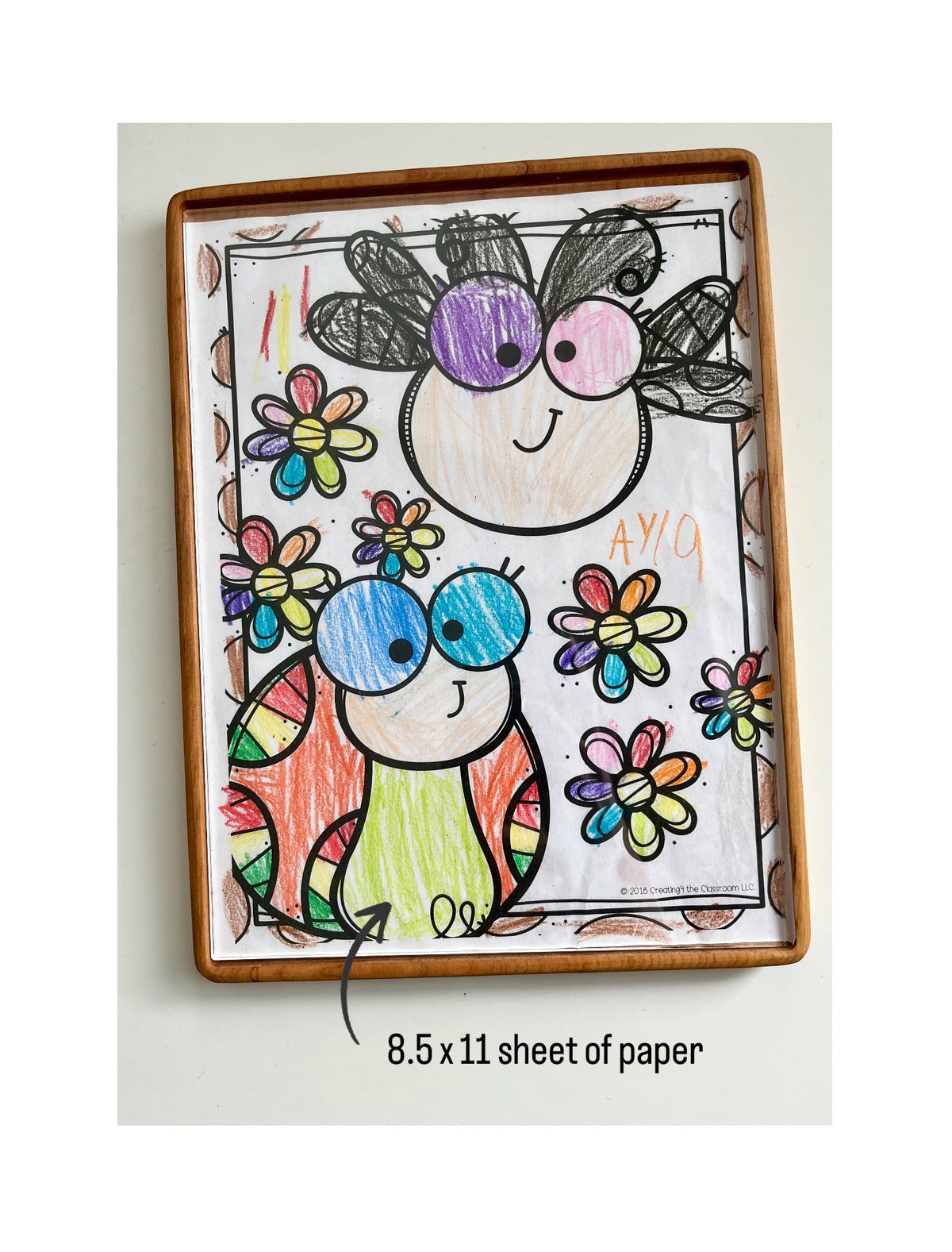 Tall wooden rectangular sensory tray holding colorful 8.5 x 11 sheet with dry erase activity inside