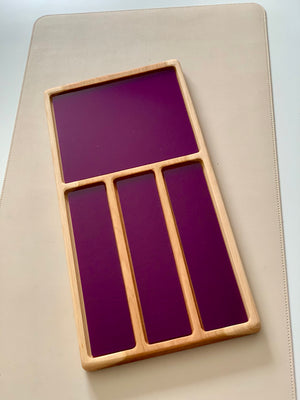 Wooden tray with one large square and three narrow vertical compartments featuring dark purple panels on a light surface