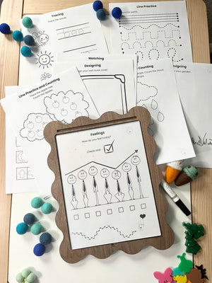 Educational worksheets on a wooden surface with a framed worksheet in the foreground.