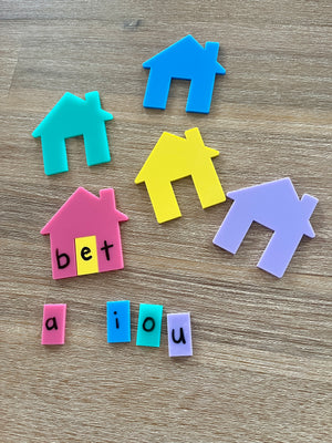 Little Dry Erasables - Houses for CVC, Math + More featuring colorful plastic house shapes and removable vowel letter tiles forming "bet" on a wood surface, handcrafted homeschool education resources.