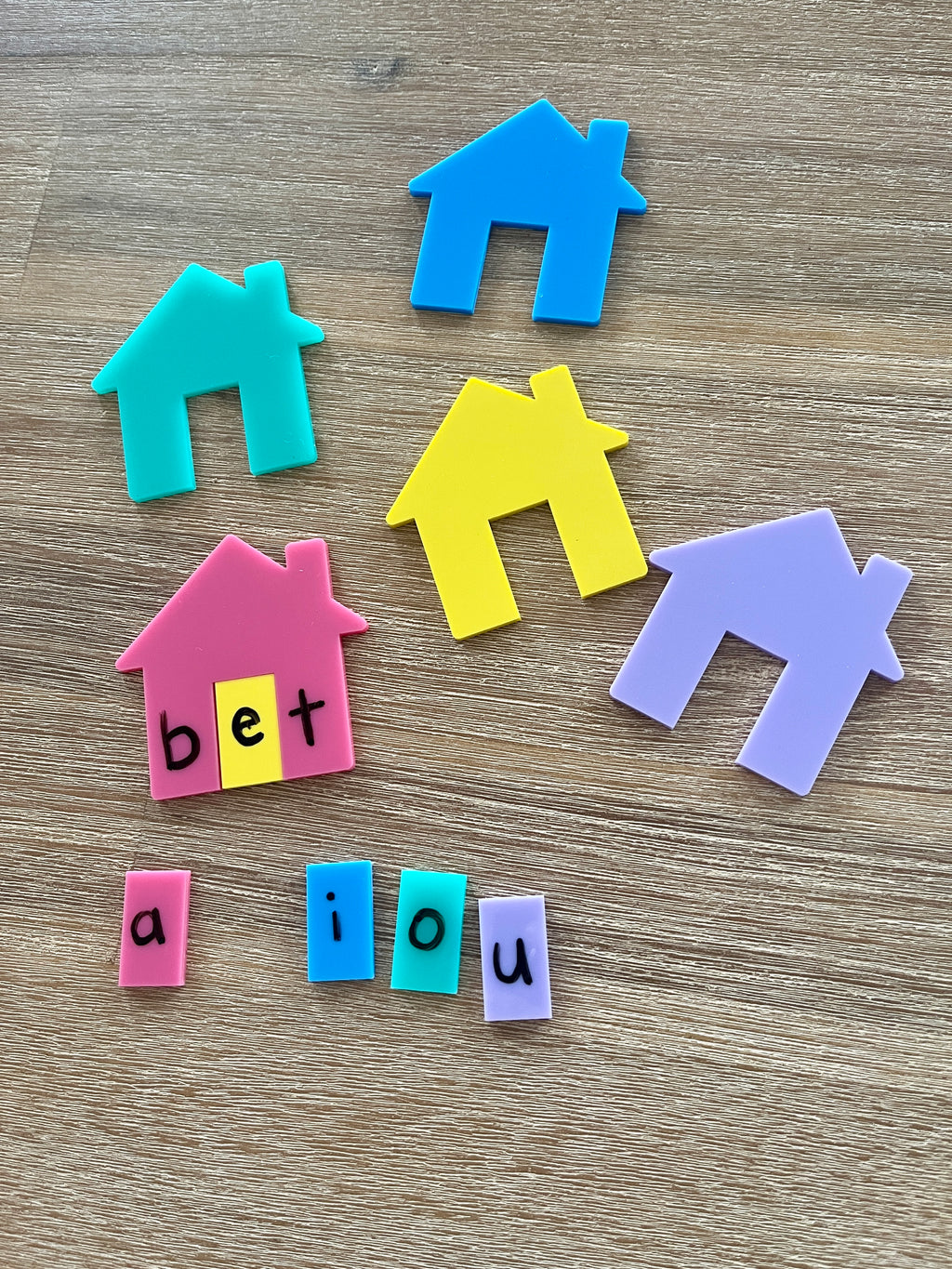 Little Dry Erasables - Houses for CVC, Math + More featuring colorful plastic house shapes and removable vowel letter tiles forming "bet" on a wood surface, handcrafted homeschool education resources.
