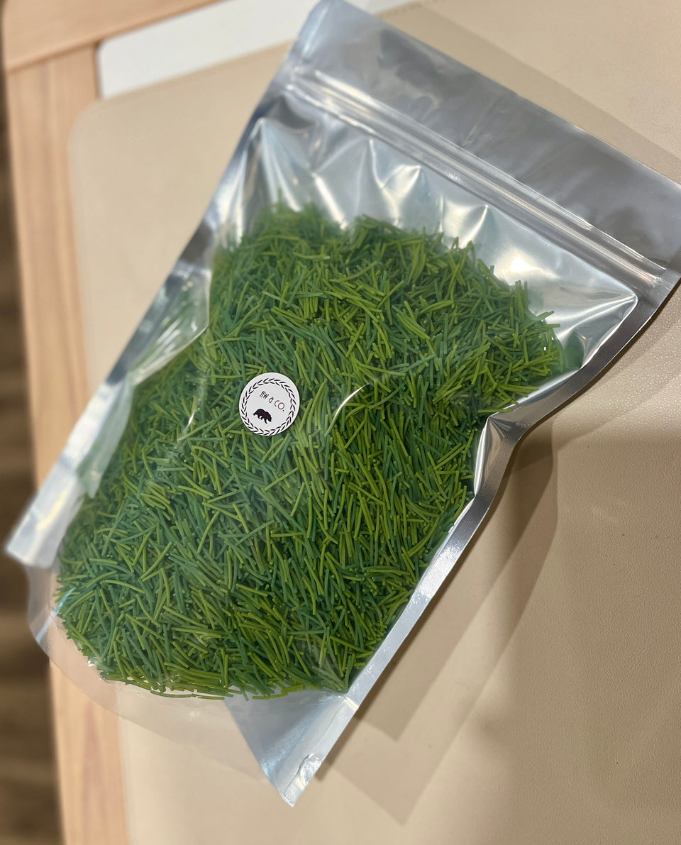 Transparent resealable bag filled with fresh green pine needles placed on a beige surface
