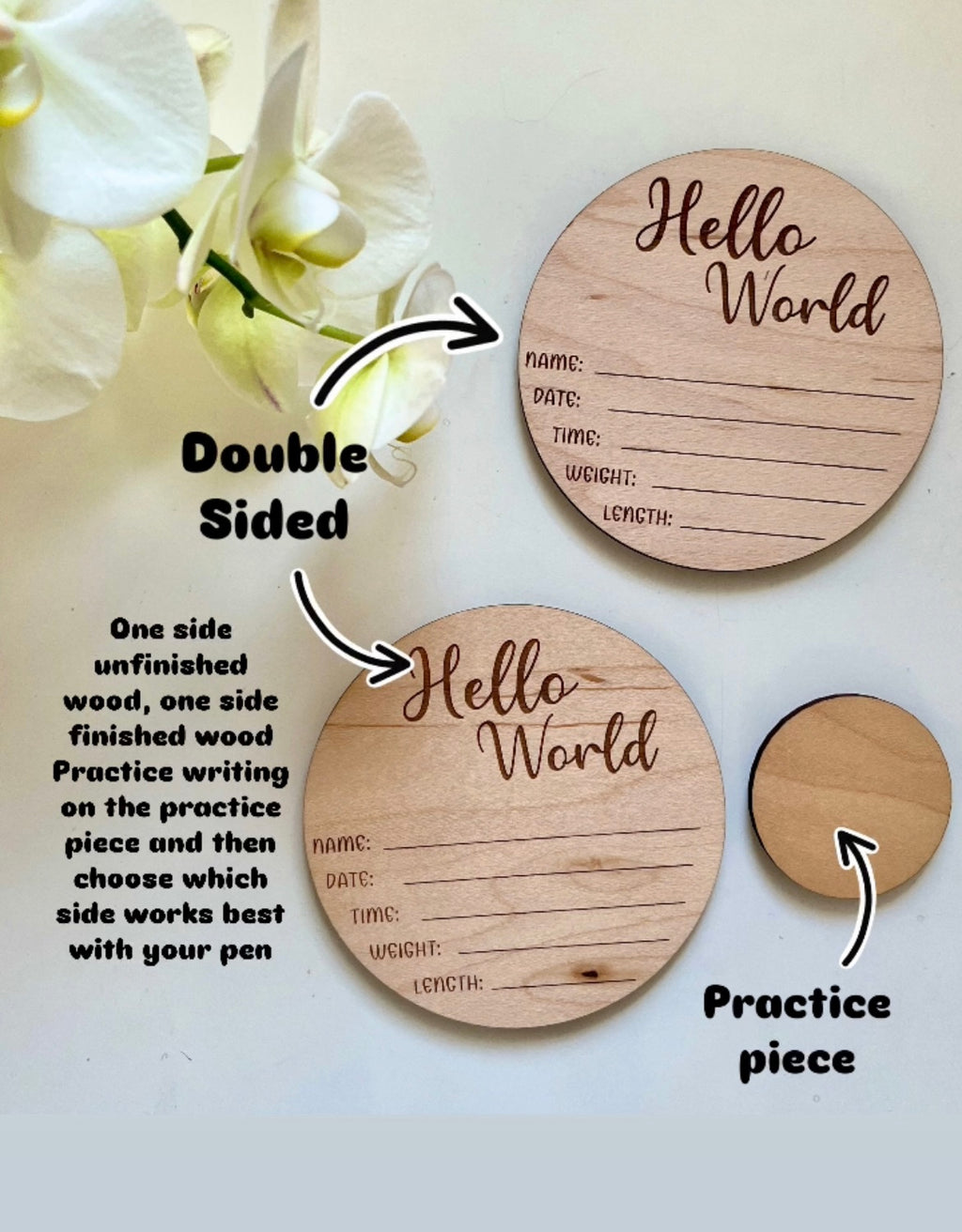 Two round wooden plaques with "Hello World" and lines for baby details, plus a small blank practice circle next to white orchids