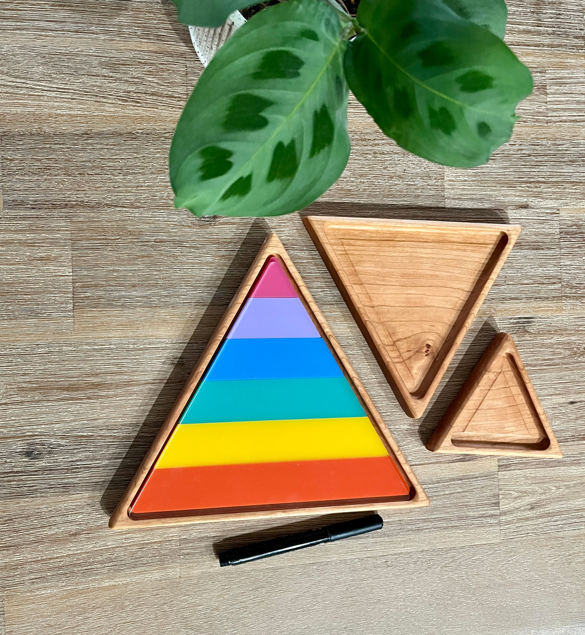 Nesting Triangle Pyramid Wooden Sensory Trays featuring handcrafted wooden trays with colorful layered triangle pieces arranged on a natural wood surface, homeschool education resources.