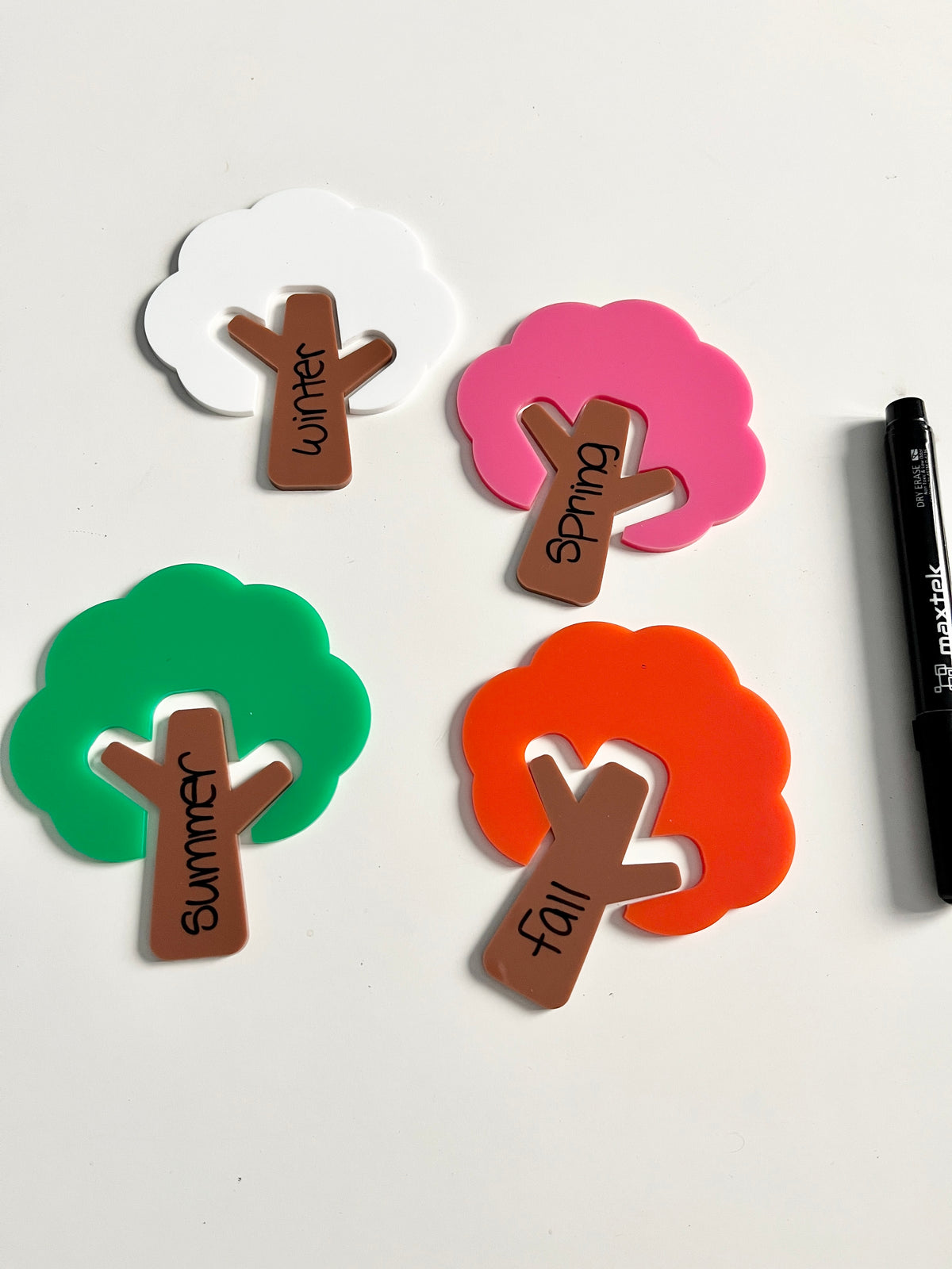 Little Dry Erasables — Trees and Tree Trunks — Colours of Seasons; Medium Version showing colorful tree shapes in white, pink, green, and orange with brown trunks labeled for each season and a black dry-erase marker, handcrafted homeschool education resources.