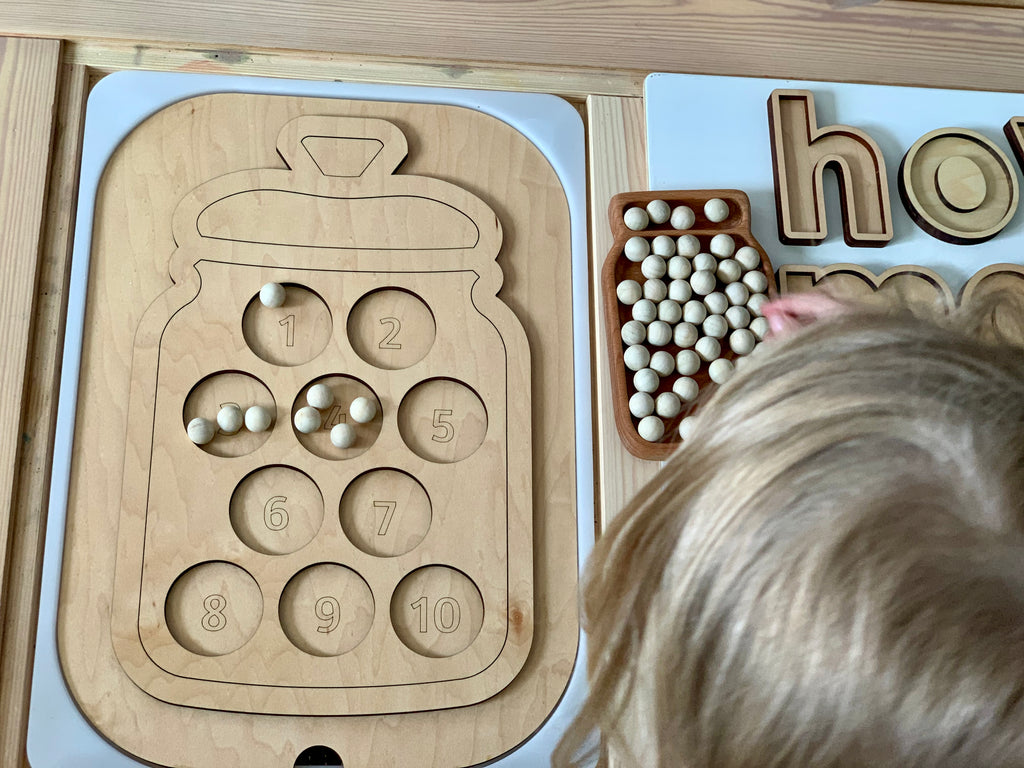 Wooden Flisat table top insert shaped like a cookie jar with ten numbered cookie slots and small wooden peg cookies
