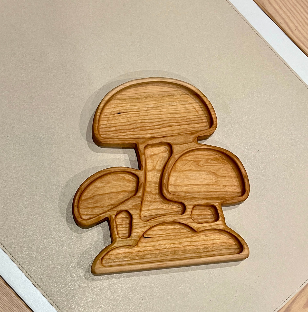 Wooden serving tray carved in the shape of three connected mushrooms with smooth natural finish