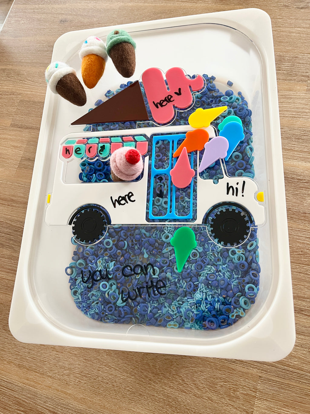 Dry Erasable Ice Cream Truck Flisat Table Bin Lid filled with blue sensory beads, colorful felt ice cream cones, and dry erase marker writing space, handcrafted, homeschool, education resources.