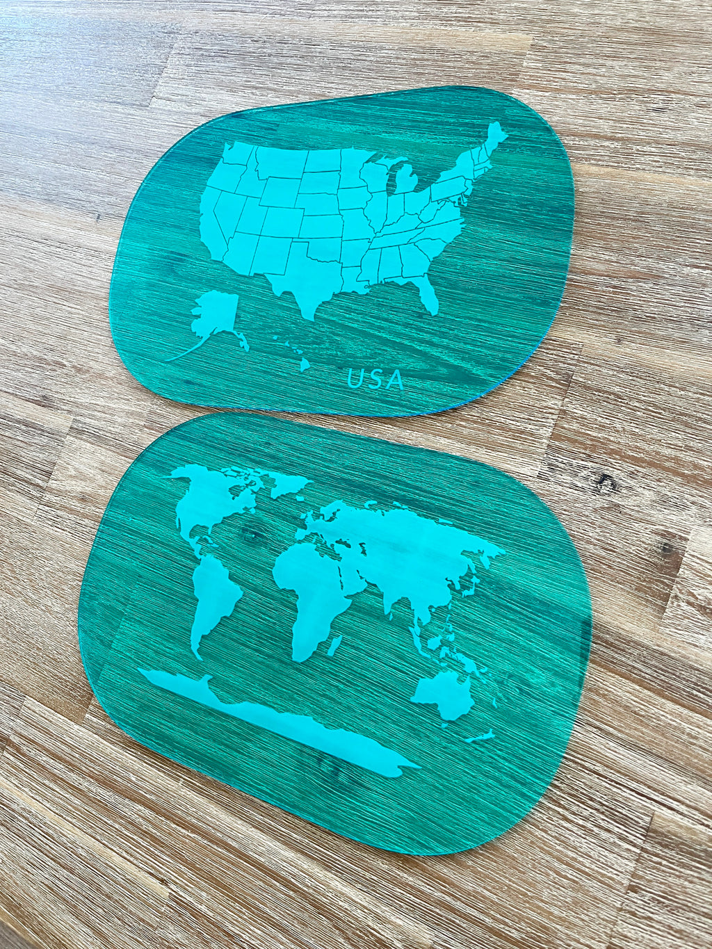 Two translucent blue acrylic tracing boards with map outlines of the USA and world, displayed on a wood surface, showcasing Translucent Blue Maps (USA, World, Canada) Dry Erase Acrylic Tracing Board; also fits as a Flisat Insert, handcrafted, homeschool, education resources.