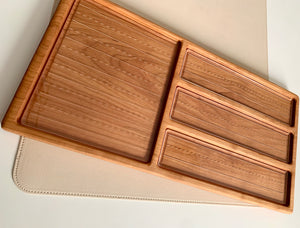 Rectangular wooden organizer with one large square compartment and three smaller elongated slots on a beige surface