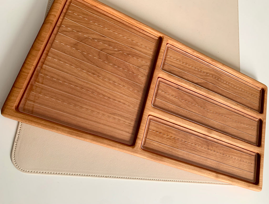 Rectangular wooden organizer with one large square compartment and three smaller elongated slots on a beige surface