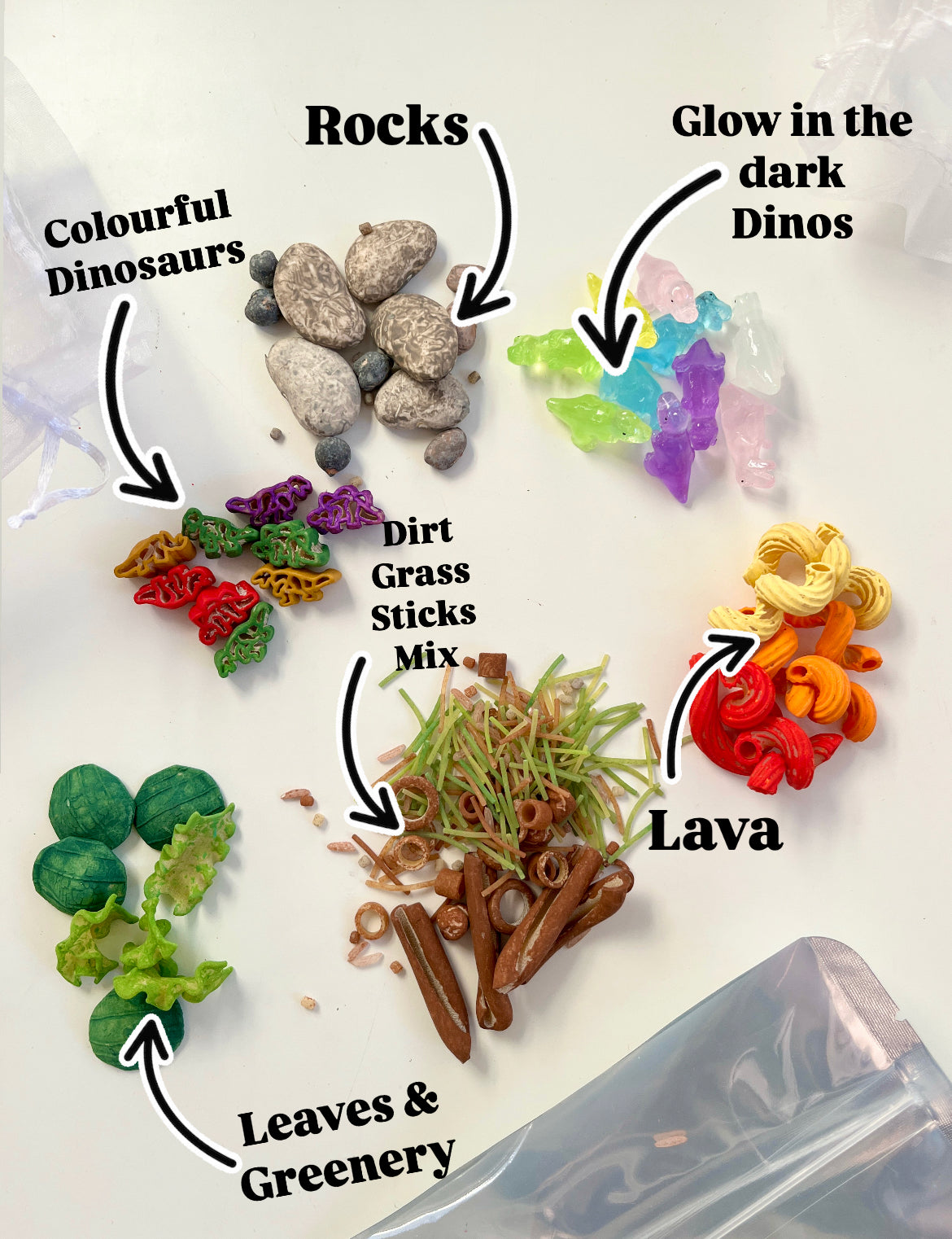 Small colorful dinosaur figures, rocks, glow-in-the-dark dinos, faux leaves, grass, sticks, and orange lava pieces on white background