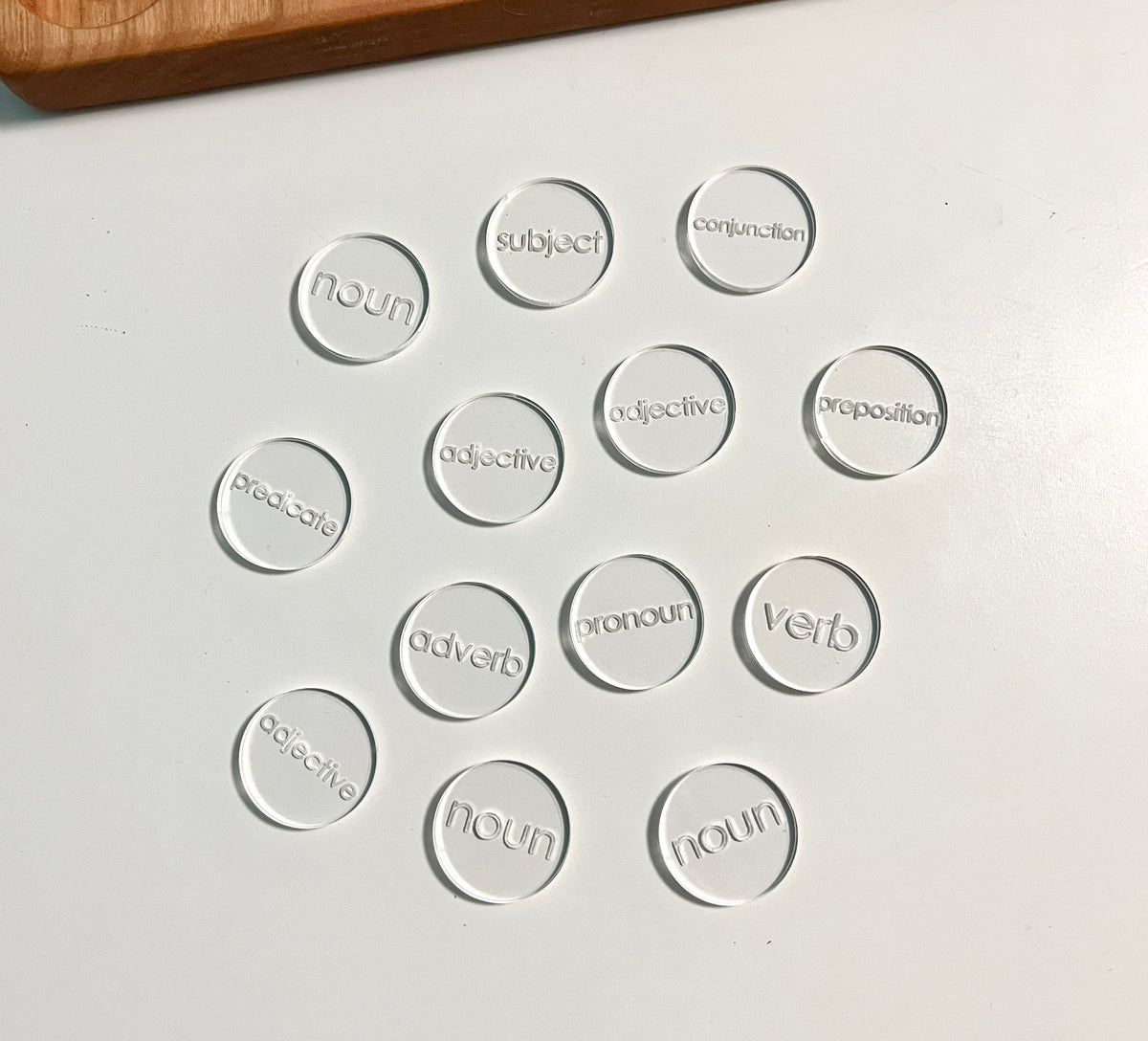 Mini Wood or Clear Acrylic Parts of Speech / Grammar Label Discs featuring clear acrylic discs engraved with various parts of speech terms, handcrafted homeschool educational resources for grammar learning.