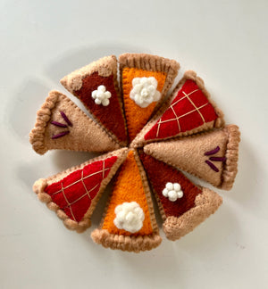 Eight felt pie slice ornaments in autumn colors arranged in a circle on a white background