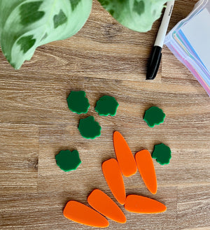 Little Dry Erasables - Small Carrots & Tops - Set of 6 / 12 Pcs Total showing bright orange carrot pieces paired with green tops arranged on a wood surface with a black marker and colorful paper, handcrafted homeschool education resources.