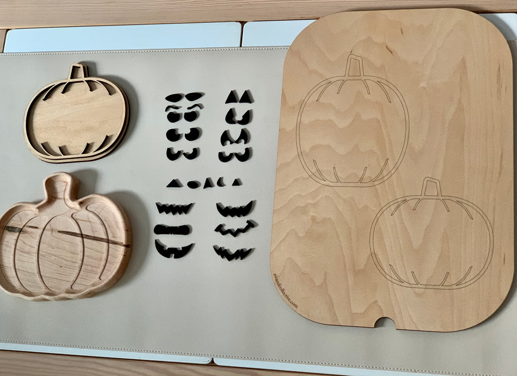 Laser cut wooden jack o lantern facial features and pumpkin shapes with slots on light surface for sensory play