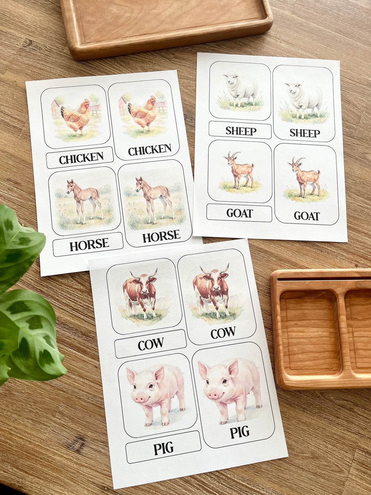 Digital Download | Farm Animal 3 Part Nomenclature Cards featuring watercolor illustrations of chicken, horse, sheep, goat, cow, and pig on a wood surface with wooden trays, handcrafted homeschool education resources.