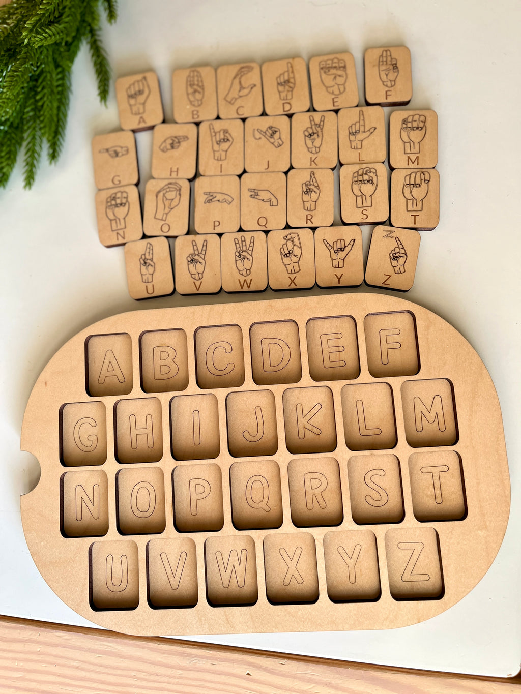 Maple wooden puzzle with removable alphabet tiles and matching American Sign Language hand signs on white surface