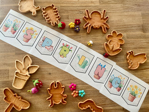 Foldable spring-themed banner spelling SPRING with pastel floral illustrations, surrounded by handcrafted wooden animal and flower-shaped trays and felt sensory toys in bright colors, for Digital Download | Spring Gardening Complete Unit Study with handcrafted homeschool education resources.