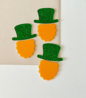 Three orange beards with green glittery top hats on beige and white background
