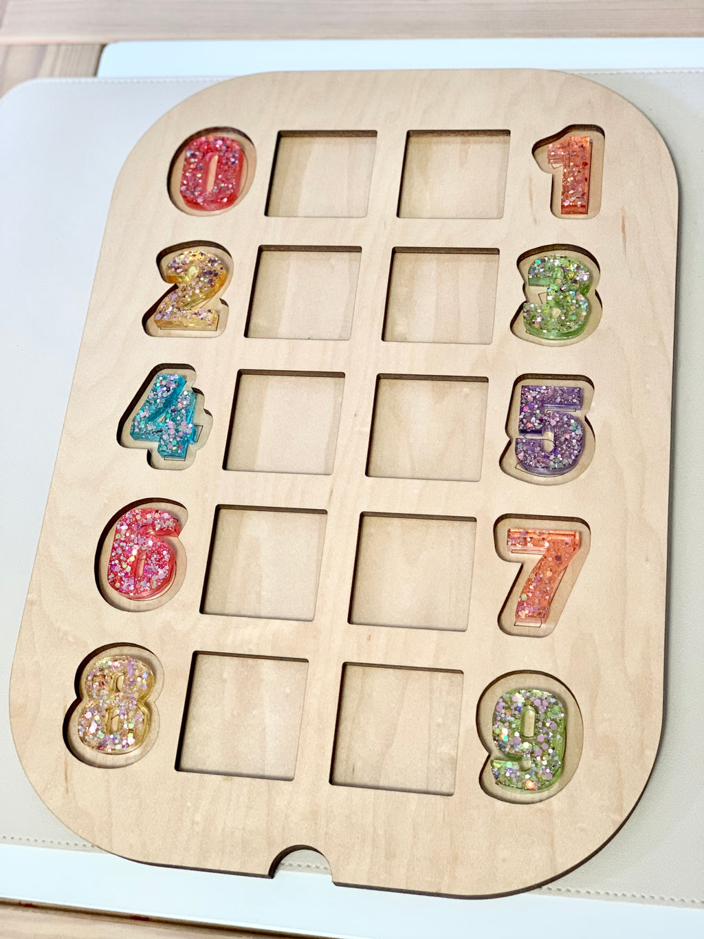 Wooden Flisat counting number puzzle insert with colorful resin numbers and empty slots on light surface