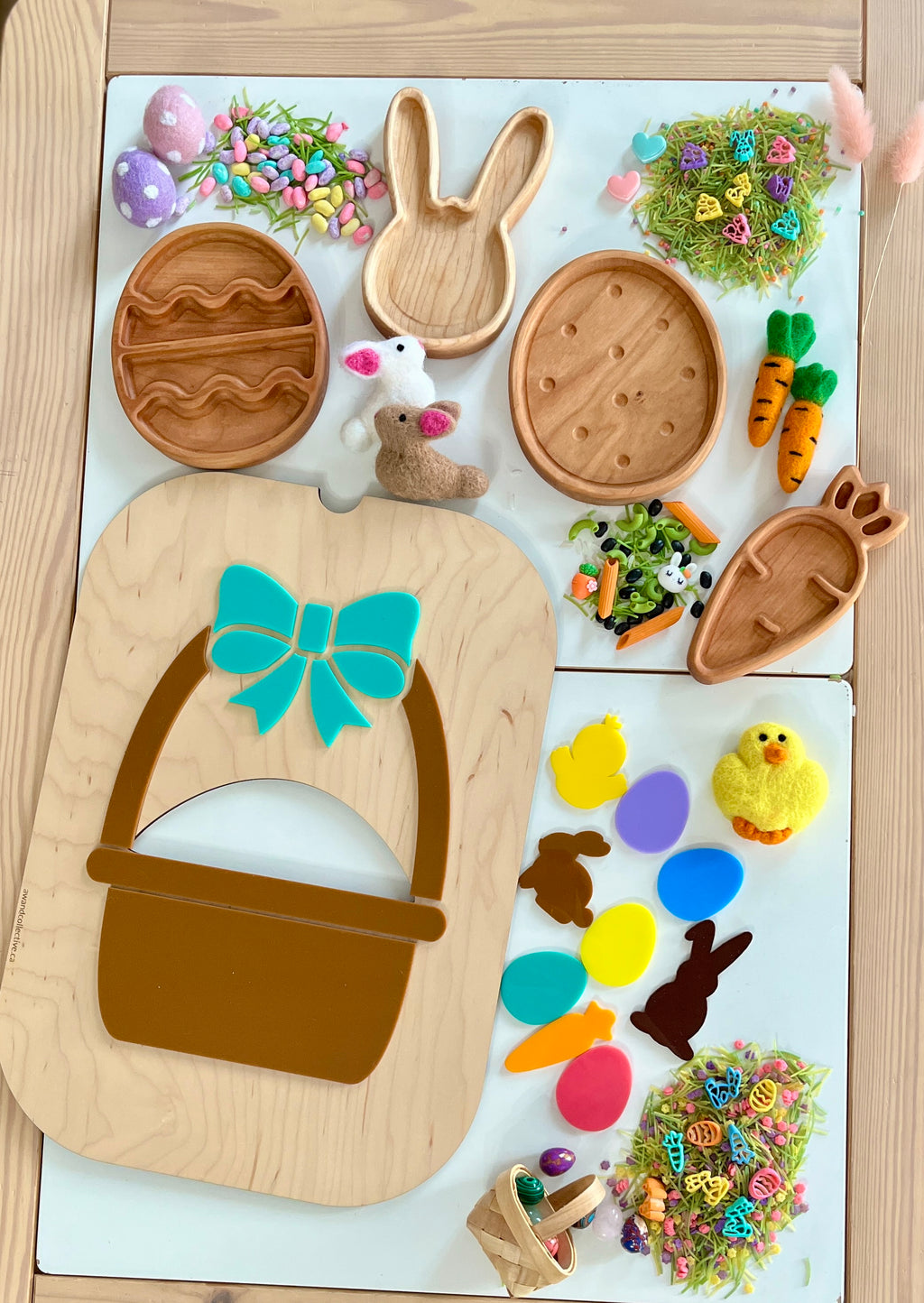 Wooden trays shaped like Easter eggs, bunny, and carrot with colorful felt and plastic Easter decorations on a table