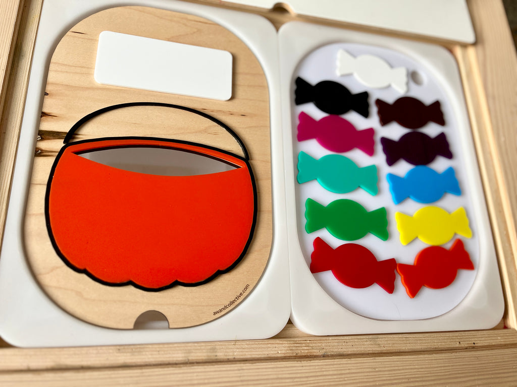 Wooden puzzle with an orange candy basket cutout and ten colorful candy-shaped pieces on a white tray