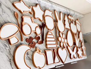 Wooden cat-shaped sensory tray with various shaped compartments and natural wood spoons on marble surface