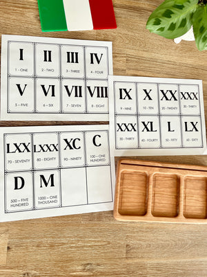 Digital Download | Roman Numeral Flash Cards displaying printable cards with Roman numerals and corresponding numbers arranged on a wooden surface next to a wooden tray, handcrafted homeschool education resources.