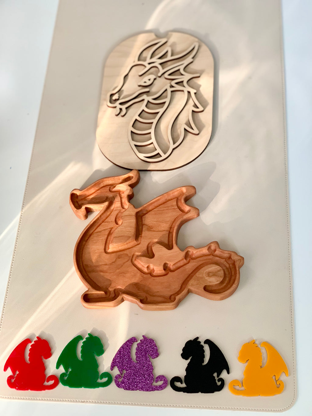 Wooden dragon puzzle with separate colorful dragon pieces in red, green, purple, black, and yellow on white background