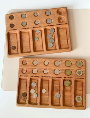 Two wooden coin sorting trays with labeled compartments holding various US and Canadian coins on a light surface