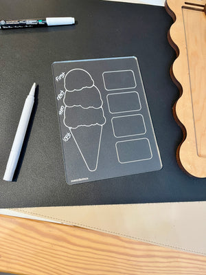 Transparent acrylic board with ice cream cone layers labeled first, next, when, last, and four rectangular boxes on black surface
