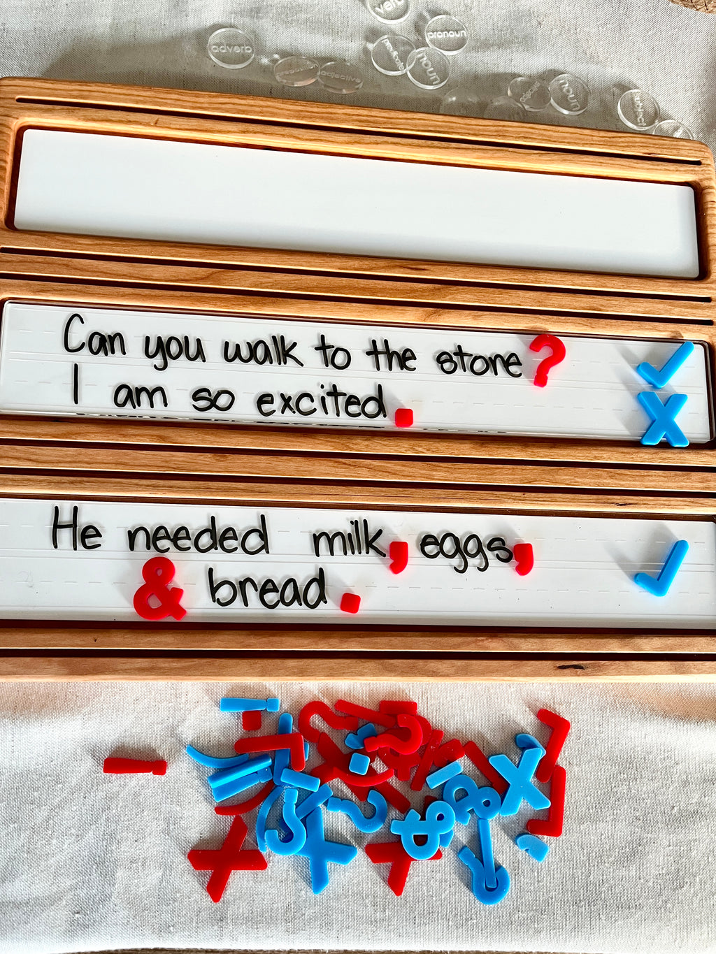Little Dry Erasables - Mini Punctuation and Loose Parts 26 Pieces arranged on handcrafted wooden trays with handwritten sentences, featuring red and blue punctuation marks, unique homeschool educational resources.