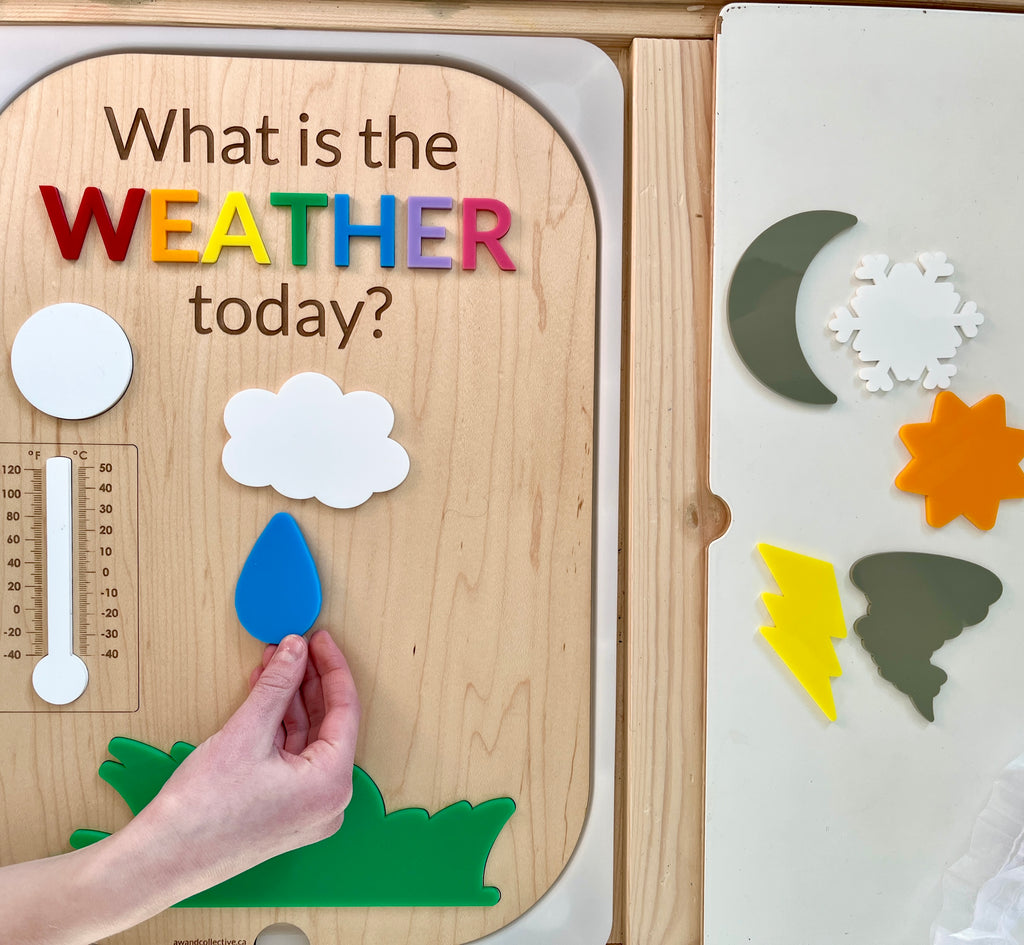 Wooden weather activity board with colorful letters and removable weather symbol pieces including sun, cloud, rain, and moon shapes
