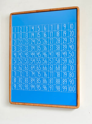 Tall wooden rectangular writing sensory tray holding blue dry erase insert with white numbers grid from 1 to 100