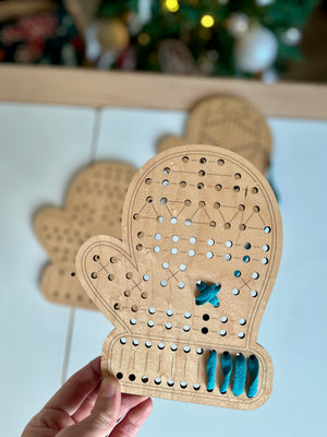 Hand holding a Mitten Lacing Boards wood toy with blue lacing thread threaded through holes, handcrafted homeschool educational resources for fine motor skill development.