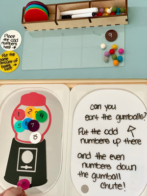 Educational board with colorful numbered discs, felt balls, and instructions for sorting odd and even numbers