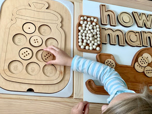 Wooden counting cookies cookie jar insert with numbered cookie slots and child placing a cookie on light wood table