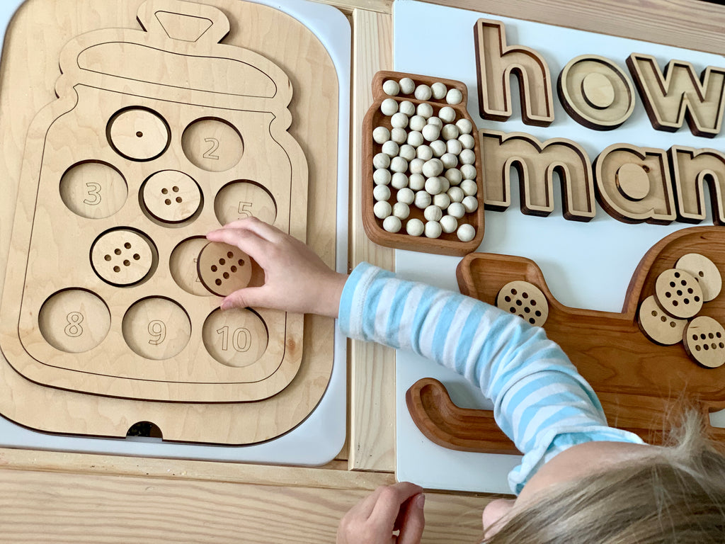 Wooden counting cookies cookie jar insert with numbered cookie slots and child placing a cookie on light wood table