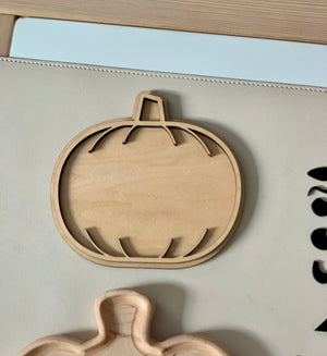 Laser cut wooden pumpkin-shaped sensory tray with carved grooves on light beige surface