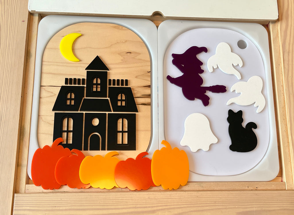 Wooden Halloween puzzle with a black haunted house under a yellow crescent moon and separate witch, ghosts, black cat, and pumpkin pieces