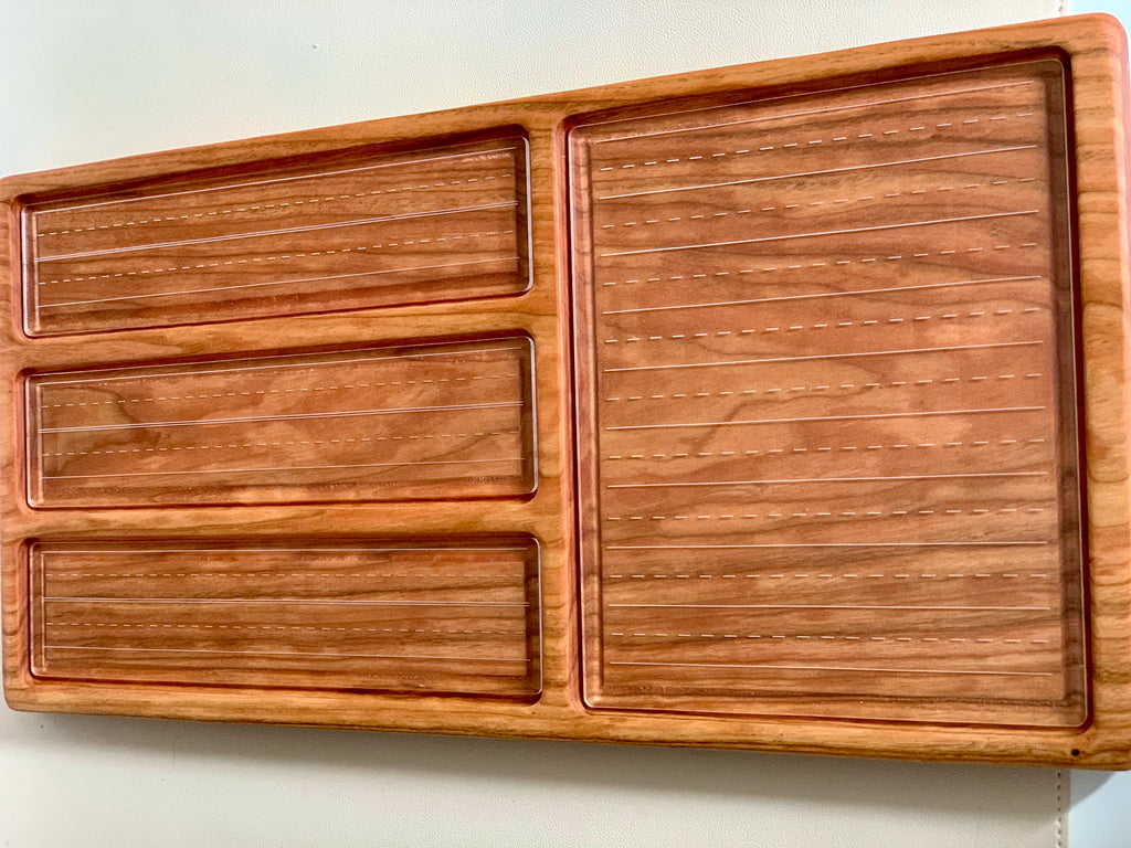 Wooden organizer tray with three long narrow compartments and one large square section on a light surface