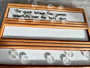 Mini Wood or Clear Acrylic Parts of Speech / Grammar Label Discs featuring clear acrylic discs engraved with parts of speech terms placed on a wooden tray with handwritten sentence for homeschool education resources.