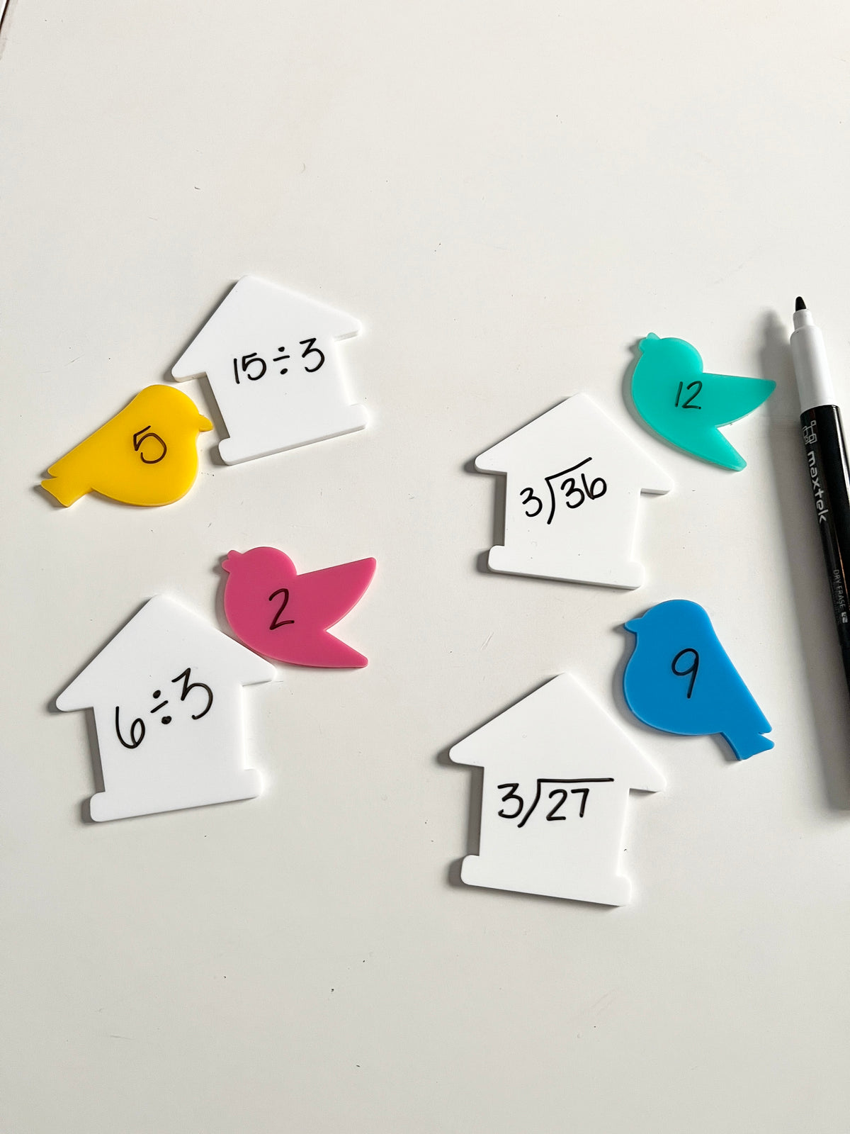 Little Dry Erasables - Birds & Houses featuring colorful bird-shaped pieces in yellow, pink, blue, and teal paired with white house shapes showing handwritten division and square root math problems, black dry-erase marker, handcrafted homeschool education resources.