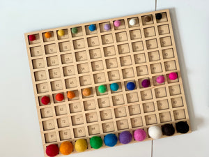 Wooden 100 frame sorting board with colorful felt balls in each numbered square on white surface